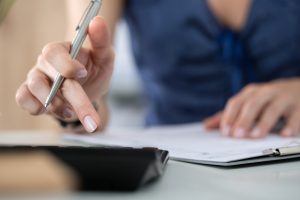 Close up of female accountant or banker making calculations. Savings, finances and economy concept
